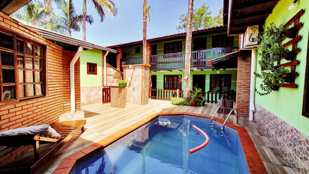 a house with a swimming pool in front of a building at Pousada do Alemão in Foz do Iguaçu