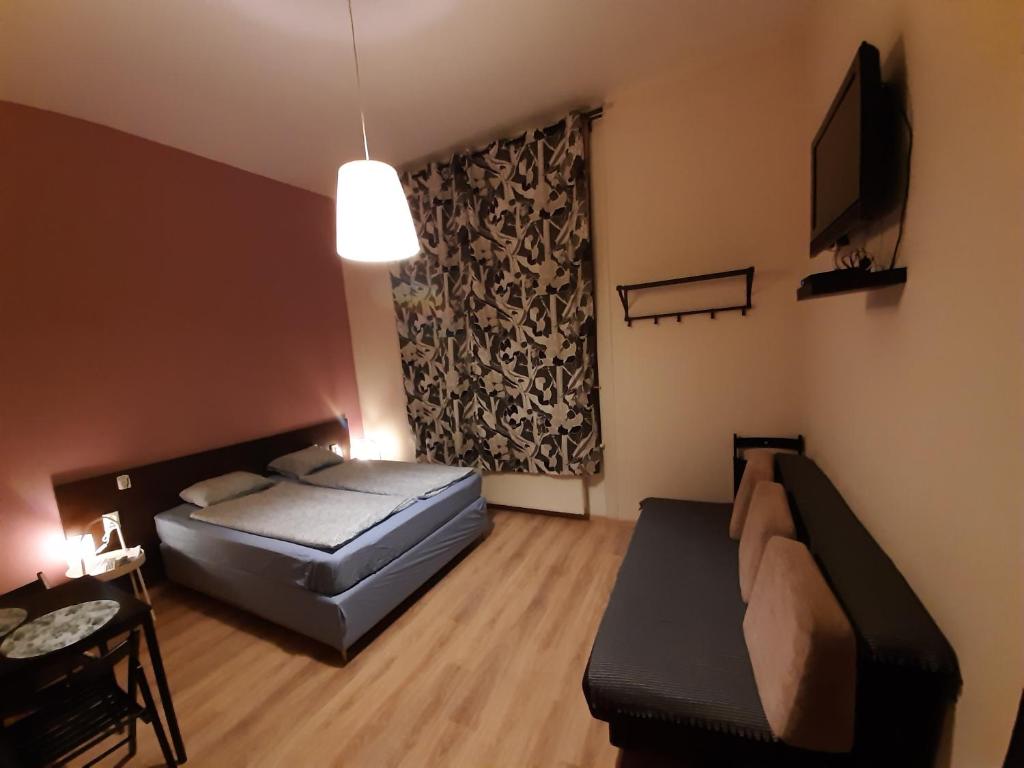 a room with two beds and a couch and a television at Downtown Apartments Budapest in Budapest
