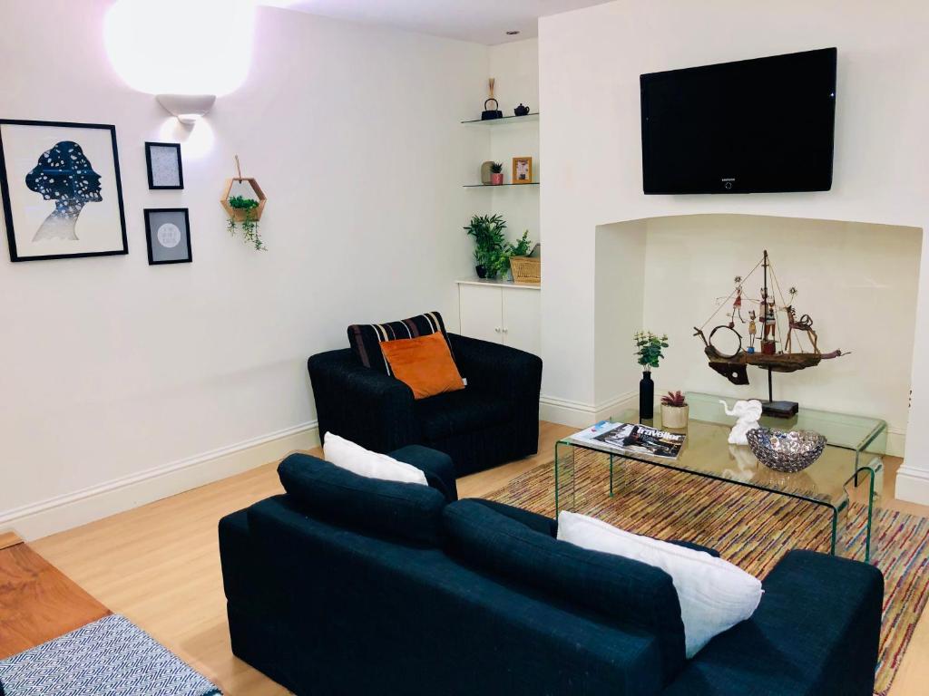 uma sala de estar com dois sofás e uma televisão em Contemporary large apartment in an ideal location em Bath
