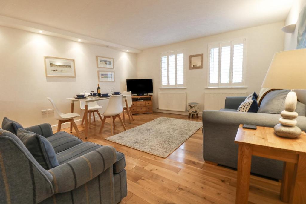 a living room with a couch and a dining room at Harbour House Apartment in Wadebridge