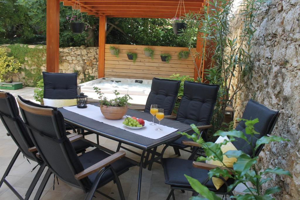 un tavolo con sedie e bicchieri da vino su un patio di Guest House Ankora a Skradin