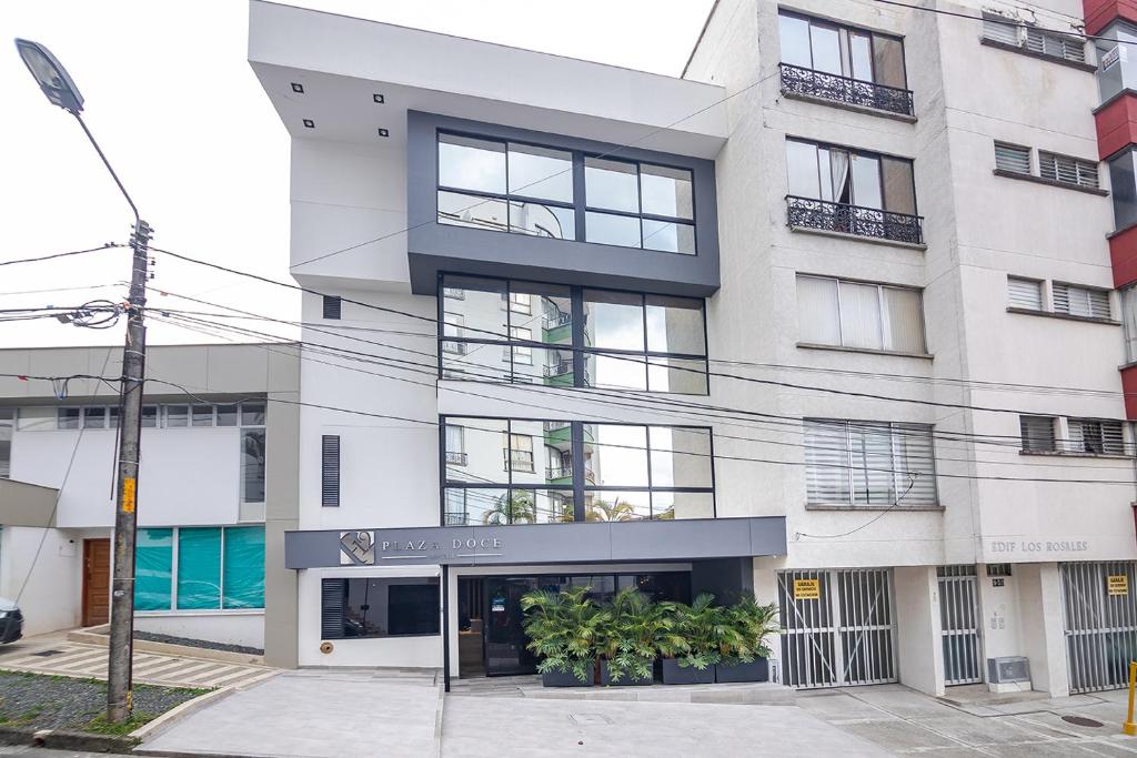 um grande edifício branco com janelas e plantas em Hotel Plaza Doce em Pereira