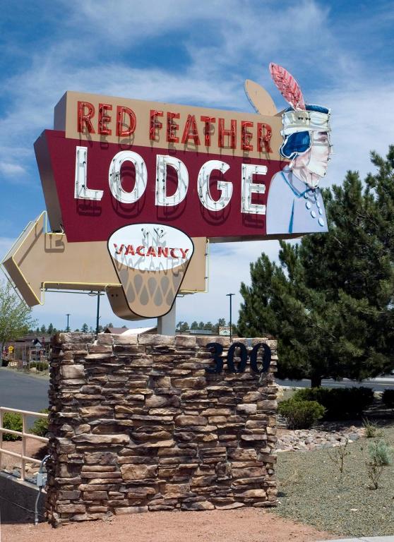 a sign for a red feather lodge on the side of a road at Red Feather Lodge/Hotel in Tusayan