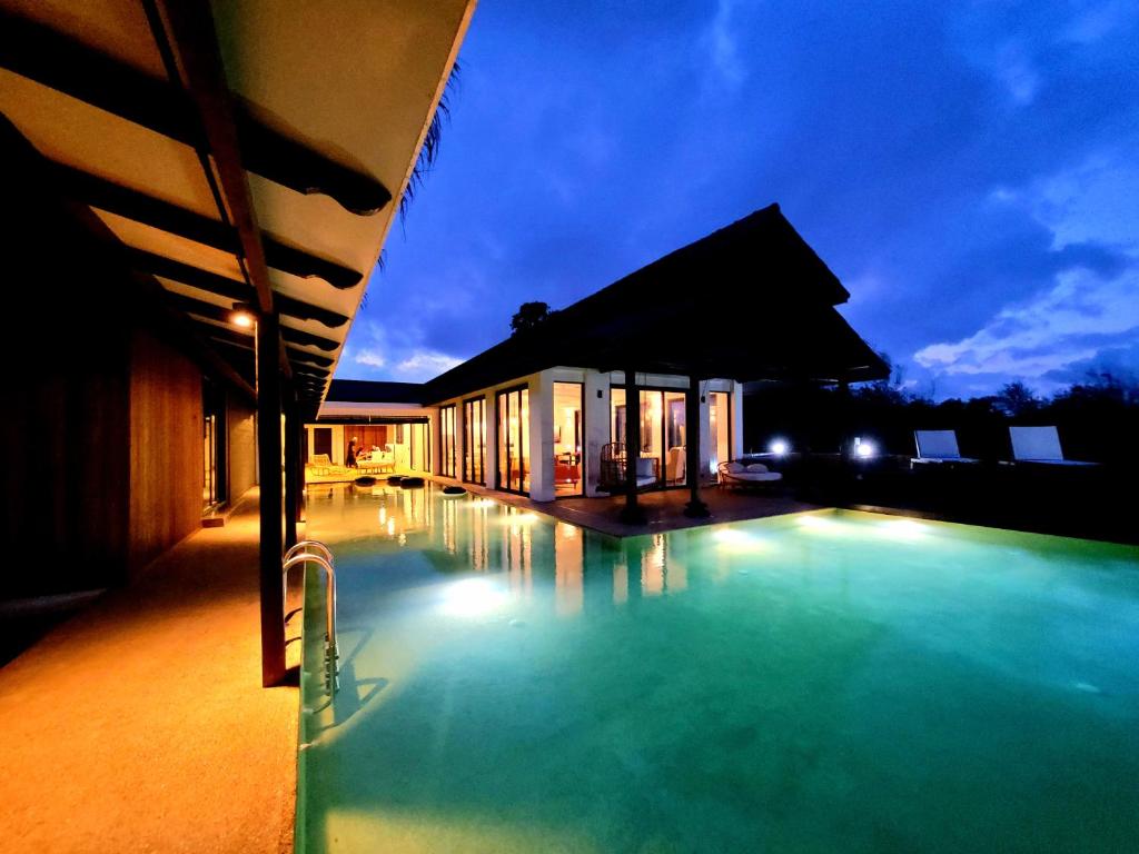 a swimming pool in front of a building at night at Villapadu Bayu in Kuala Terengganu