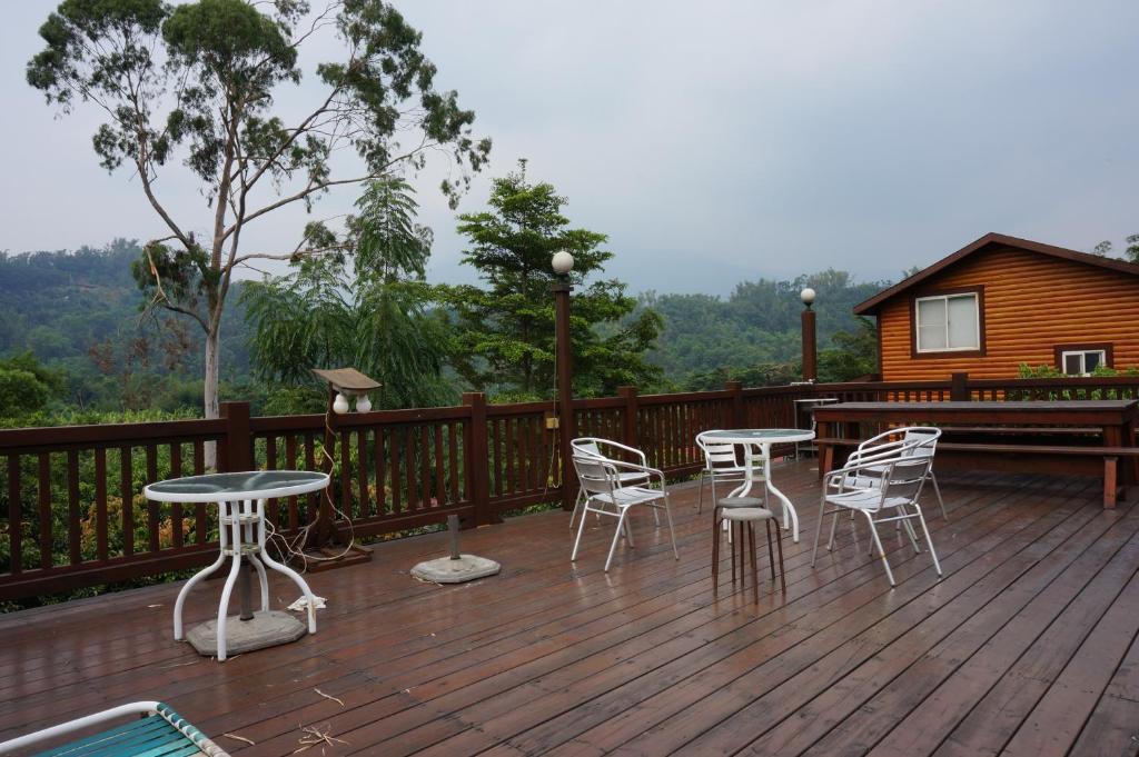 a deck with tables and chairs and a cabin at Ji Ji Farm Homestay in Jiji