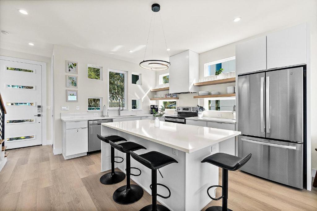 a kitchen with white cabinets and a large island with bar stools at 192 Riberia - Downtown Waterfront Luxury Home in Saint Augustine
