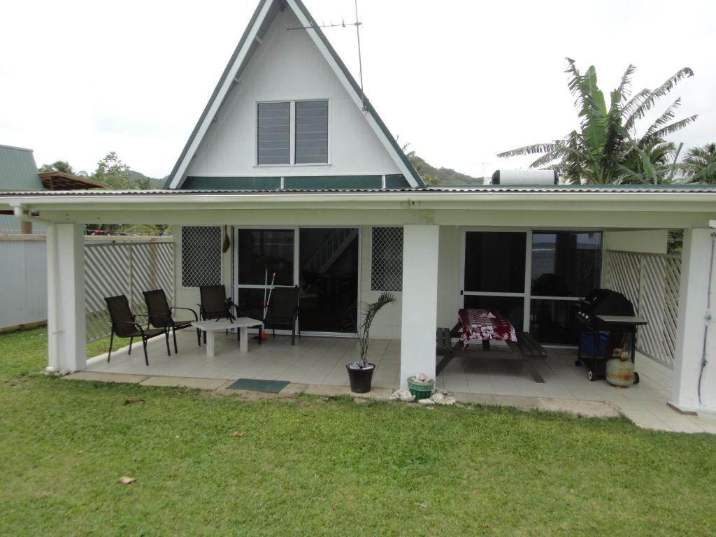 a house with a porch with chairs and a table at Betela Beach House in Rarotonga