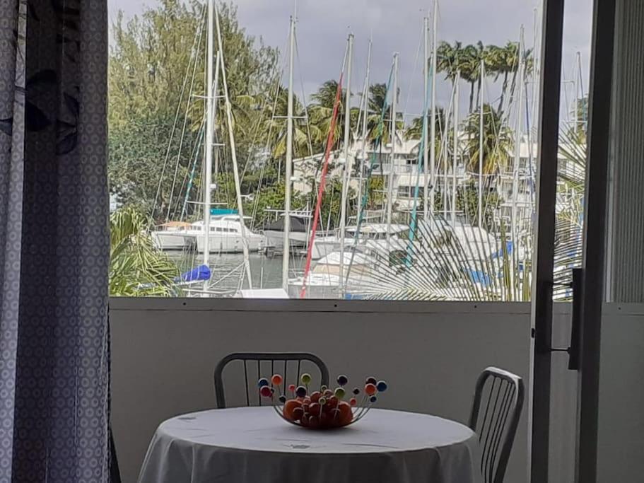 uma mesa com vista para uma marina com barcos em BEAU STUDIO DUPLEX em Les Trois-Îlets