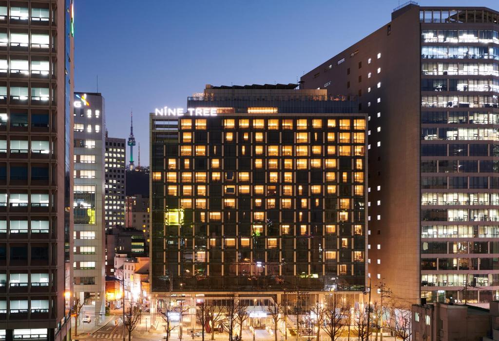 首爾的住宿－明洞九樹2號精品酒店，夜晚在城市的高楼