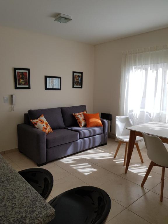 una sala de estar con un sofá y una mesa en Departamento en Mendoza confortable y tranquilo, en Godoy Cruz