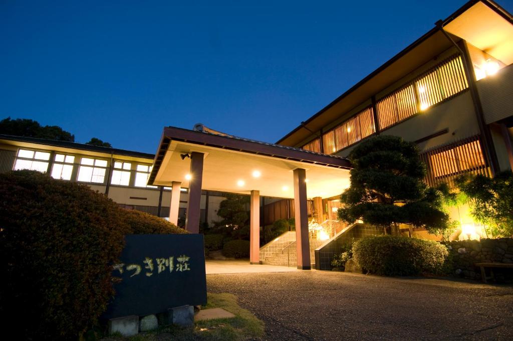 um edifício com uma placa à frente à noite em Satsuki Bessou em Tamana