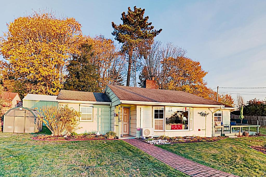 a small house on a grassy field with trees at Sunsets over Sound in Des Moines