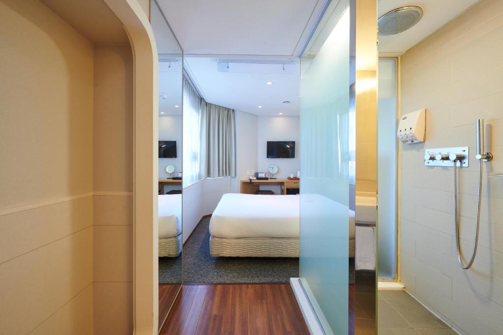 ソウルにあるナイン ツリー ホテル ミョンドンのベッドとバスルーム付きのホテルルームです。