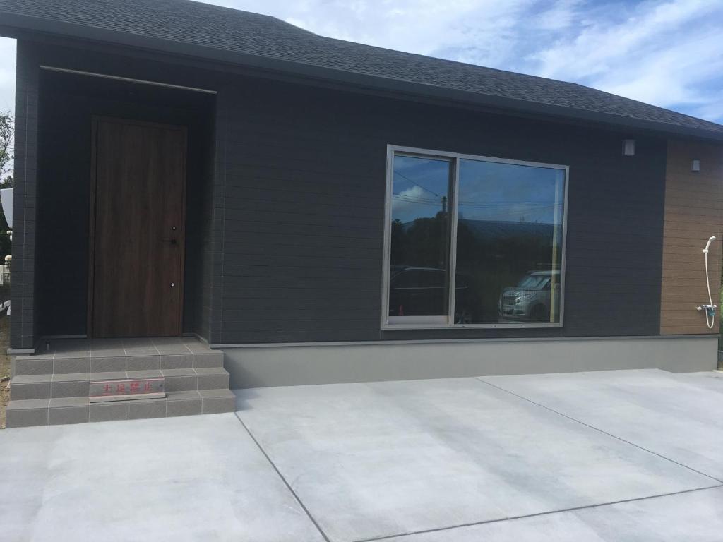 a black house with a door and a window at KAI Ichinomiya in Ichinomiya