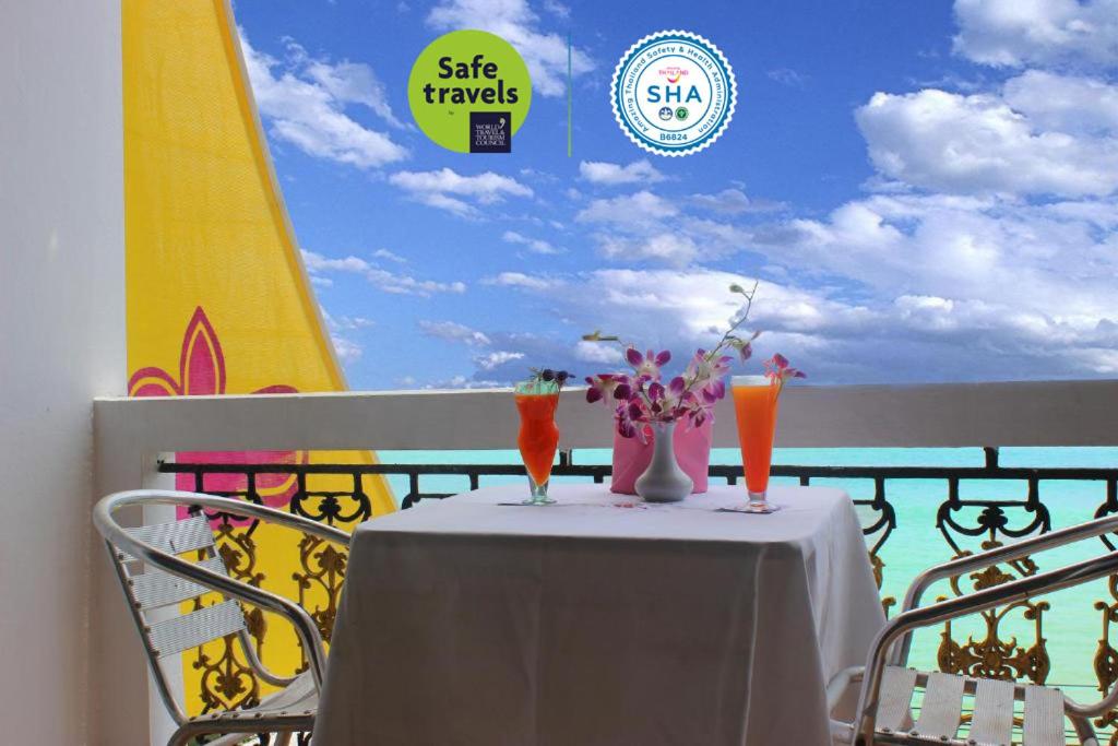 una mesa con un mantel blanco y algunas bebidas en ella en Orchid Hotel and Spa Kalim Bay, en Patong Beach
