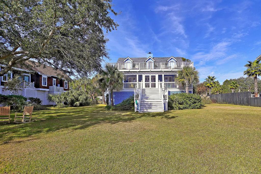 a large white house with a fence and a yard at 2714 Bayonne Street in Sullivans Island