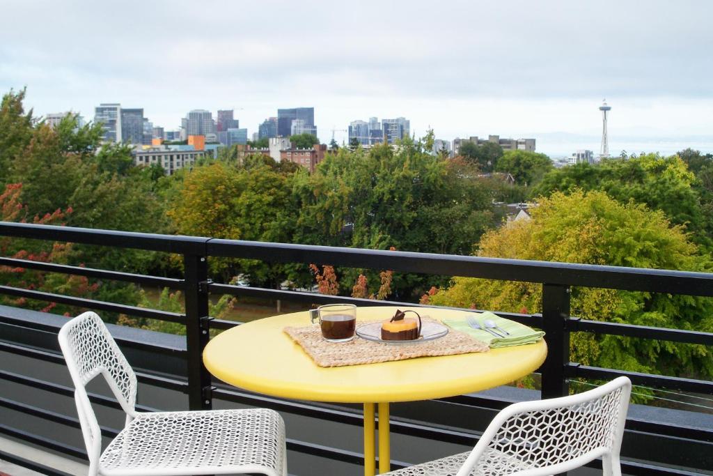 une table et des chaises jaunes sur un balcon avec vue dans l'établissement Atrium Unit 105, à Seattle