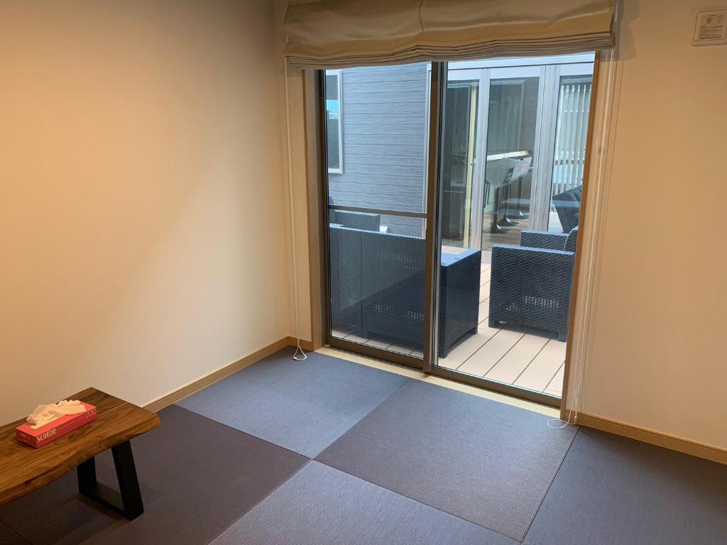 a room with a window and a table and a balcony at KAI Ichinomiya in Ichinomiya