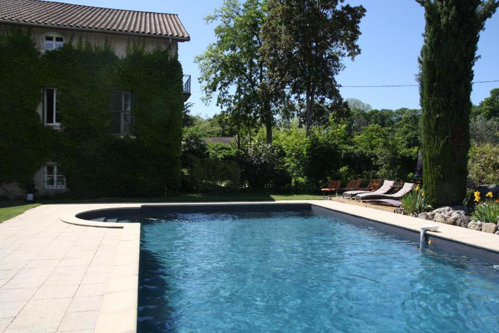 a swimming pool in the yard of a house at Chambre d'hôtes Park des Collines - Gîte in Génissieux