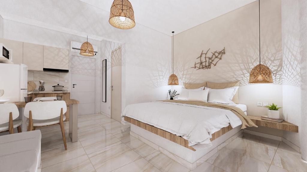 a white bedroom with a bed and a kitchen at Chouzourakis Studios in Keratokampos