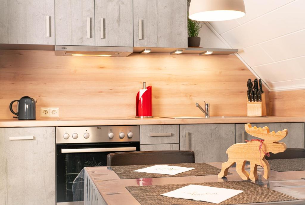 a kitchen with a table with a wooden animal on it at Ferien-Apartment im Genusshotel Hirschen (Südschwarzwald) in Kleines Wiesental