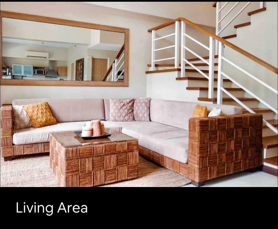 a living room with a couch and a table at Pico de Loro 2 BD Garden Loft with Lagoon View in Nasugbu