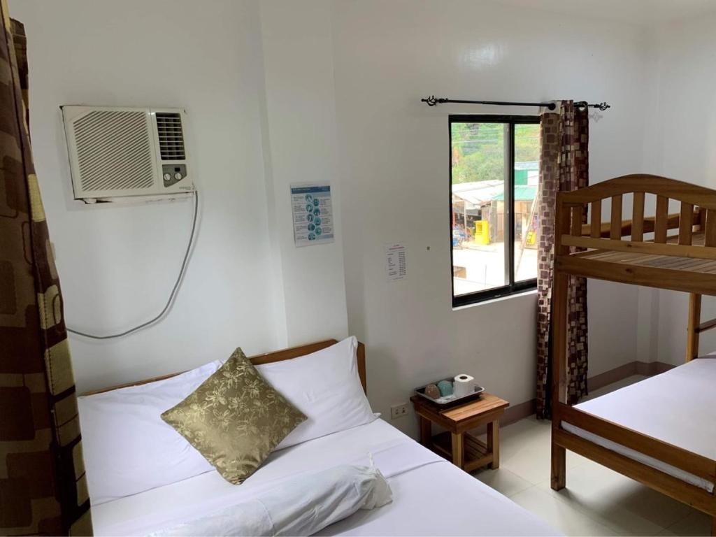 Schlafzimmer mit einem Bett, einem Ventilator und einem Fenster in der Unterkunft Sheryl May Inn in El Nido
