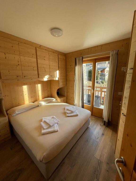 a bedroom with a large bed with towels on it at Trilocale Ortles - Residenza Vallecetta 2 in Piatta