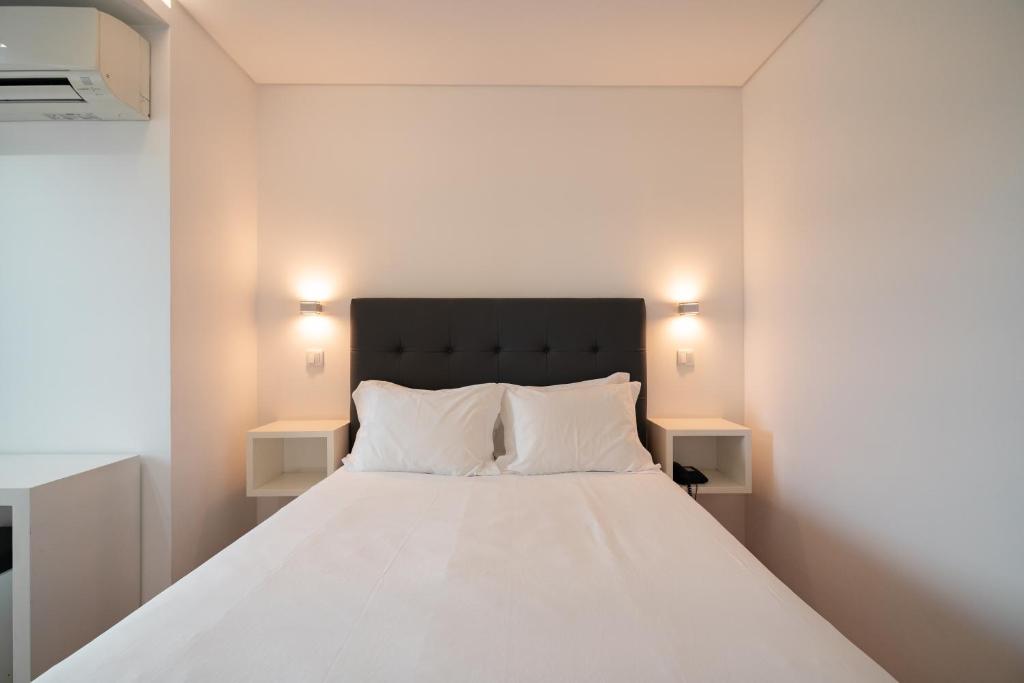 ヴィアナ・ド・カステロにあるHotel A Ponteのベッドルーム1室(白い大型ベッド1台、ナイトスタンド2台付)