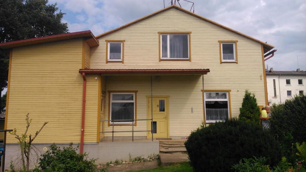 żółty dom z żółtymi drzwiami w obiekcie Kähri Home Accomodation w mieście Valga