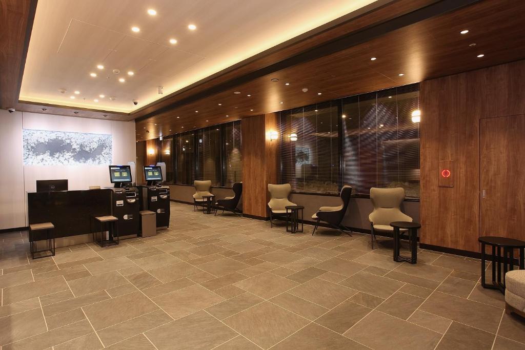 a lobby with a waiting room with chairs and tables at Sapporo Washington Hotel Plaza in Sapporo