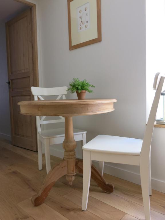 a table and a chair with a potted plant on it at Les Petits Volets 3 appartements au choix in Antibes