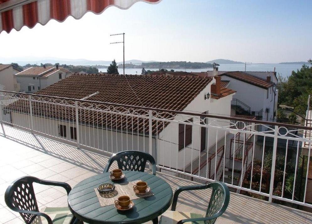 a table and chairs on a balcony with a view at Apartments Celine & Fabienne in Brodarica