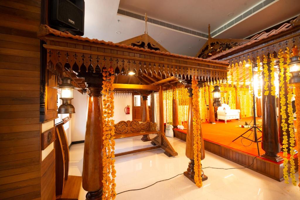 グルヴァイアールにあるHotel Guruvayur Darshanのベッド1台とカーテンが備わる客室です。