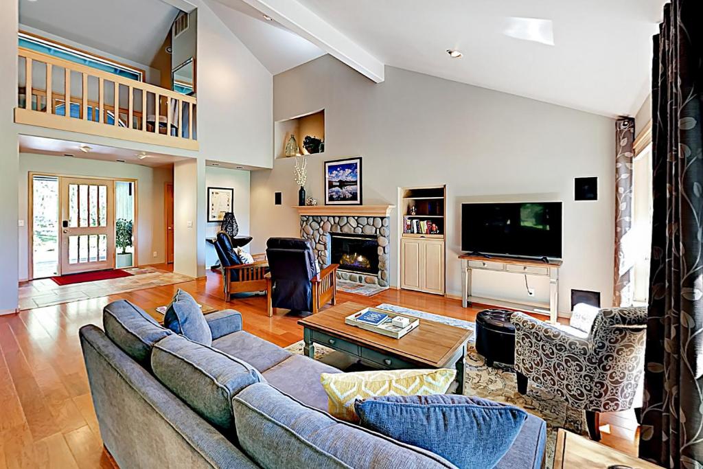 a living room with a couch and a tv at Tree Branch Cabin in Sunriver