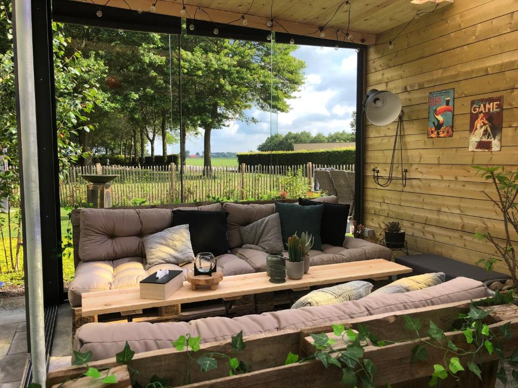 a patio with a couch and a coffee table at Feel@Home De Westhoek in Koekelare