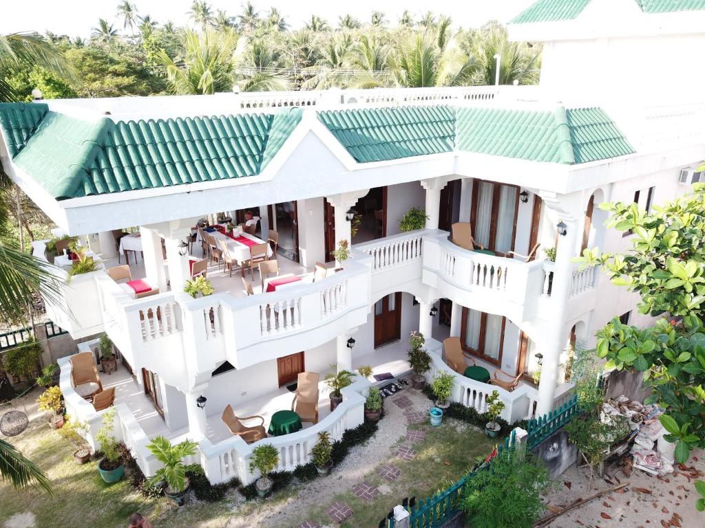 una vista aérea de una casa blanca con techo verde en The Beach House Carabao Island en San Jose