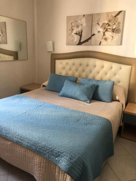 a bedroom with a large bed with blue pillows at B&B Andy&LU in Rome