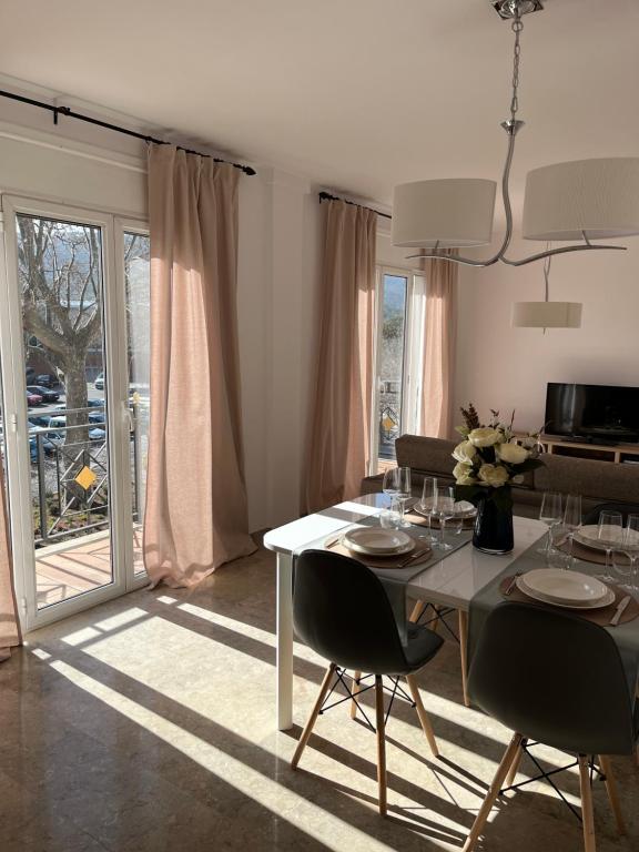 una sala da pranzo con tavolo e sedie bianchi di Apartamento luminoso Paloma a 350 metros de la playa con parking gratuito a Sant Feliu de Guíxols