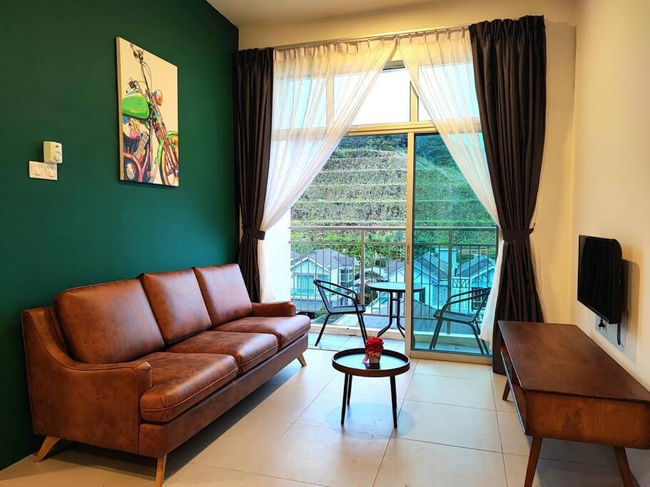 uma sala de estar com um sofá e uma grande janela em W39C WarmStay atGoldenHill NightMarket 2R WiFi CarPark em Brinchang