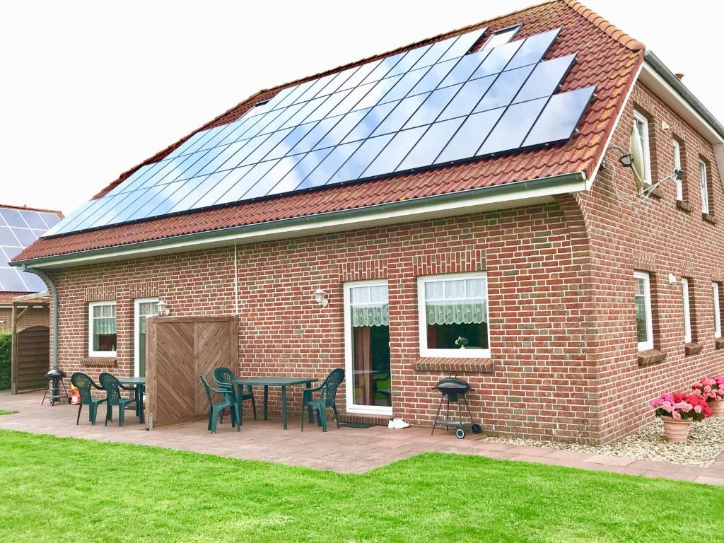 a red brick house with a table and chairs at Ferienwohnungen Koch EG adult only in Wangerland