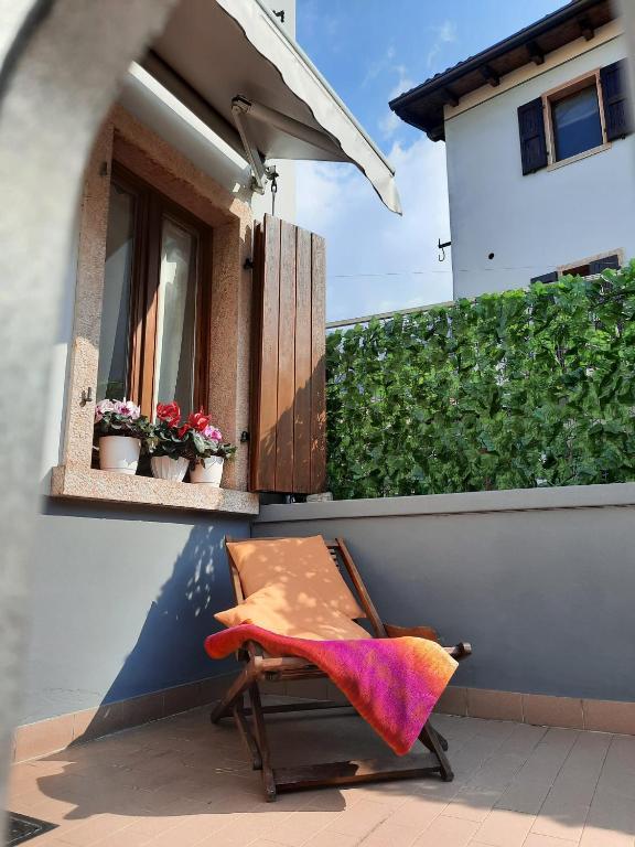 a chair sitting on a balcony with a window at Casa Edda in Malcesine