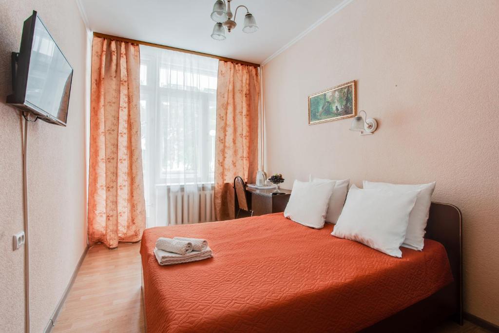 モスクワにあるPeredelkino Sanatoryのベッドルーム1室(オレンジのシーツが入ったベッド1台、窓付)