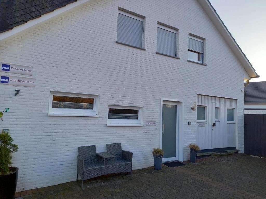 a white building with two chairs in front of it at City-Apartment Rietberg in Rietberg