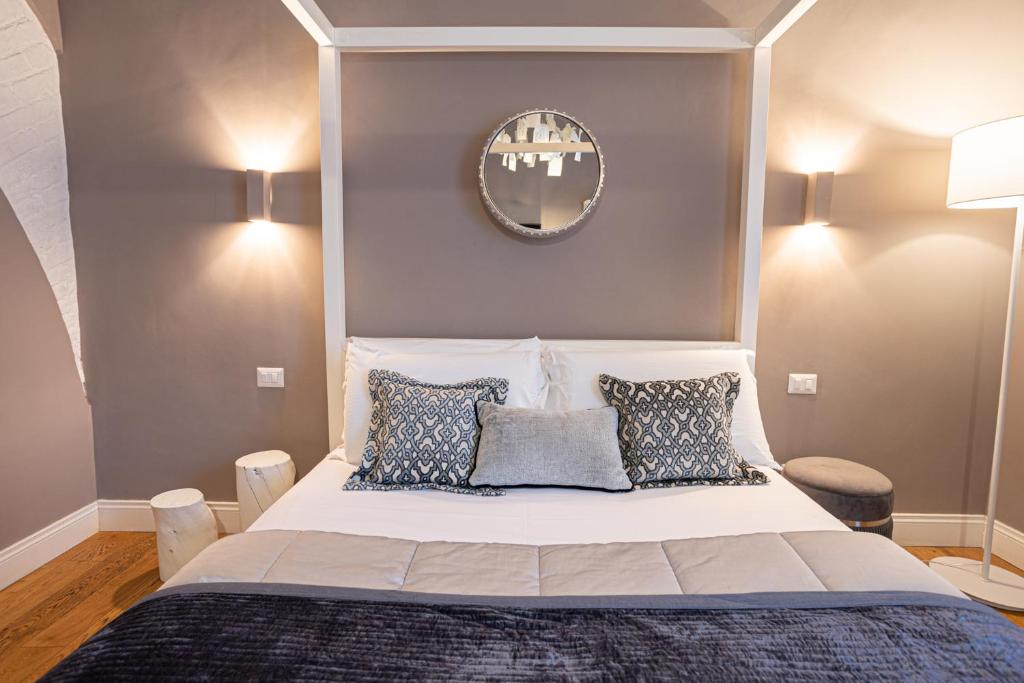 a bedroom with a bed with pillows and a mirror at Cardilli Luxury Rooms in Rome