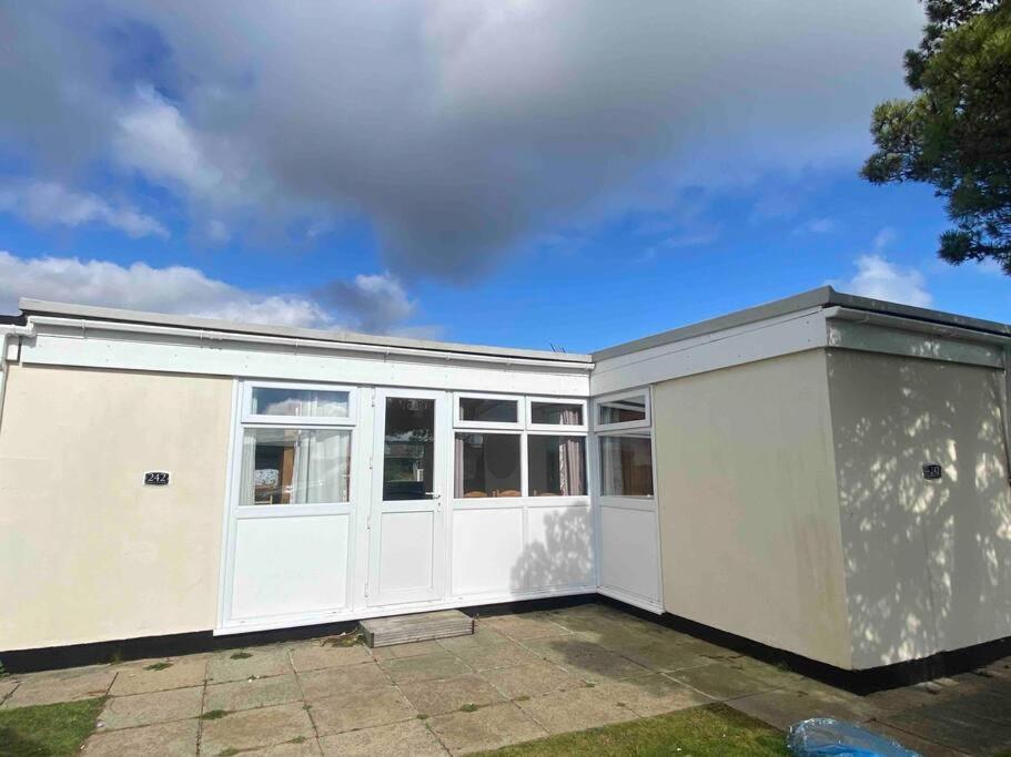 a large white garage with white doors and windows at Chalet Escapes in Kidwelly