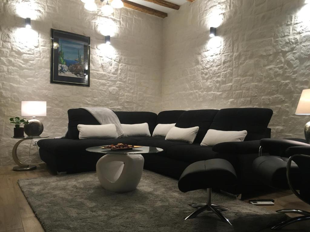 sala de estar con sofá negro y mesa en Luxury Apartment KASTELA ANTIKA, en Rovinj