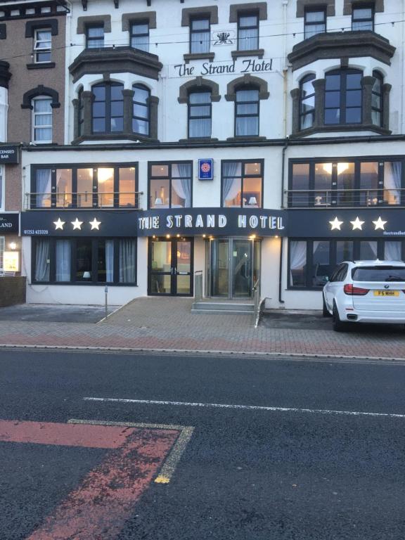 a white car parked in front of a hotel at The Strand Hotel in Blackpool