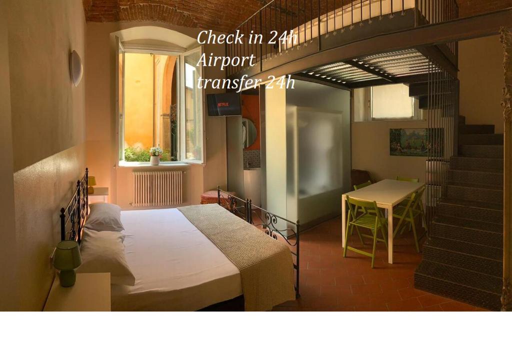 1 dormitorio con cama, mesa y escalera en Bergamo Bella B&B, en Bérgamo