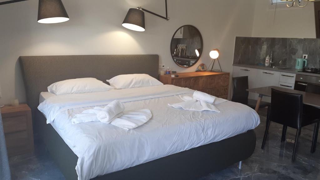 um quarto com uma cama grande com lençóis brancos e almofadas em GIANNIS em Galatás